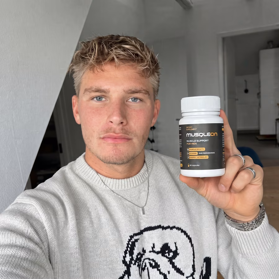 Ung blond man i vit tröja som tar en selfie med en burk Musqleon